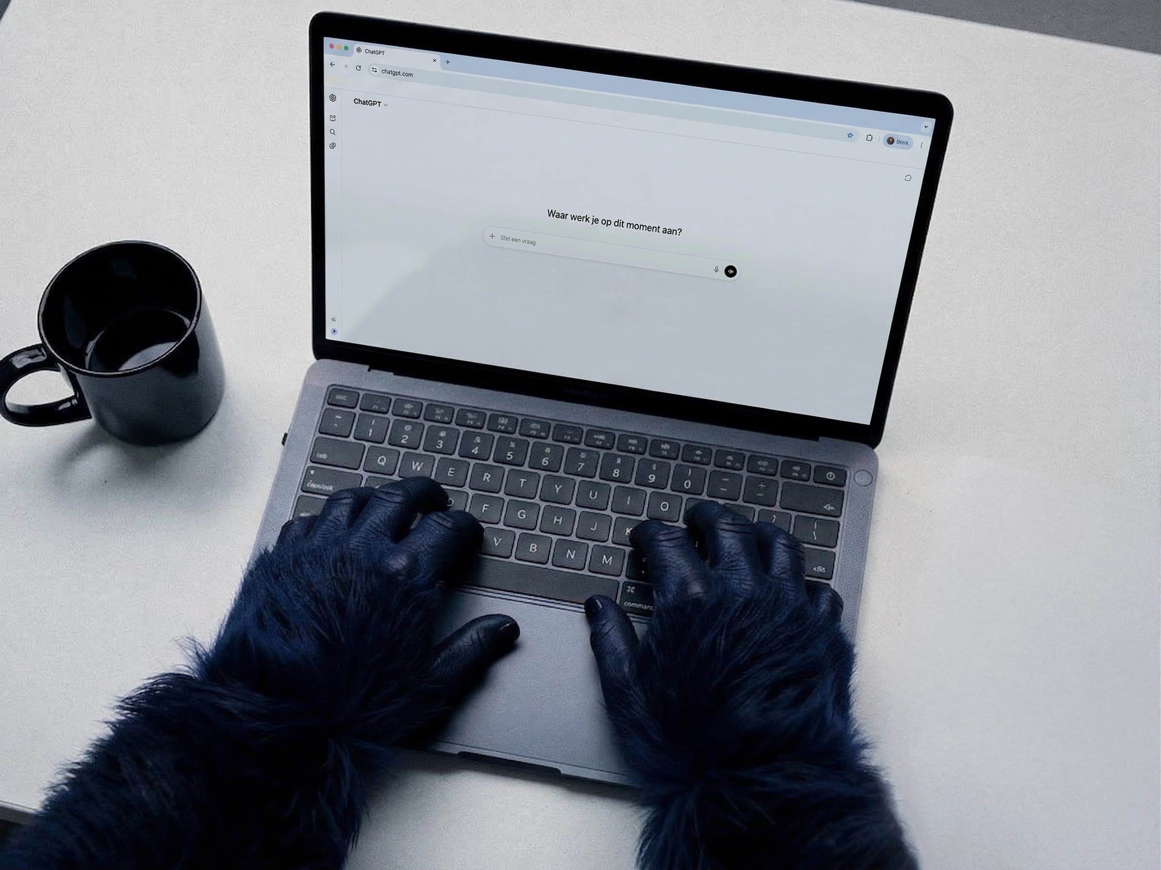 Blauwe gorilla handen typen op een laptop met de ChatGPT interface open op het scherm, naast een kop koffie