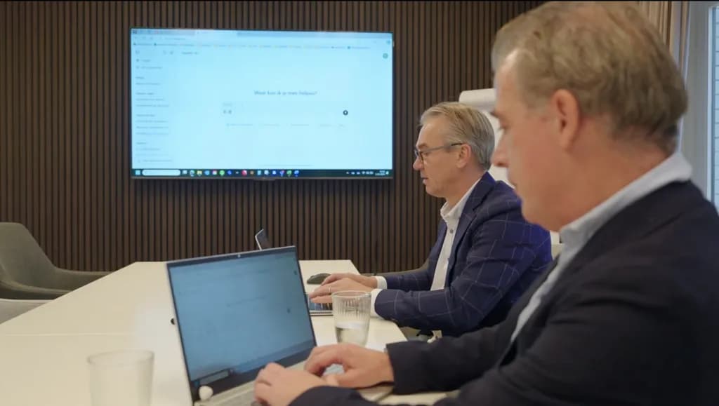 Twee directieleden van BIQ Investments werken samen met ChatGPT op een groot scherm tijdens een AI-sessie