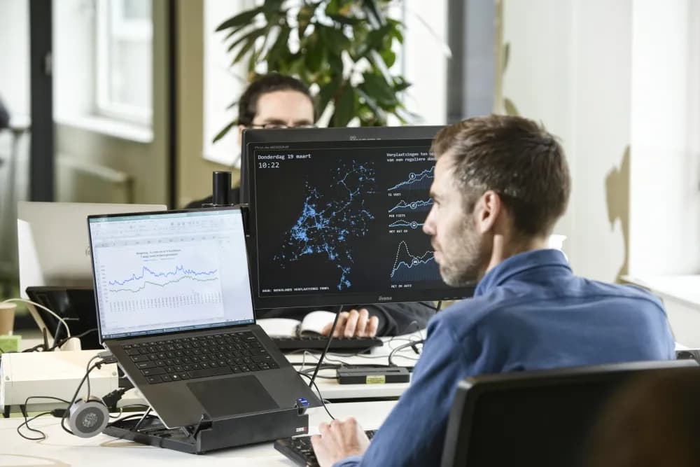 Medewerker van Goudappel analyseert verplaatsingsdata en grafieken op meerdere schermen op kantoor, als beeld bij de Goudappel case