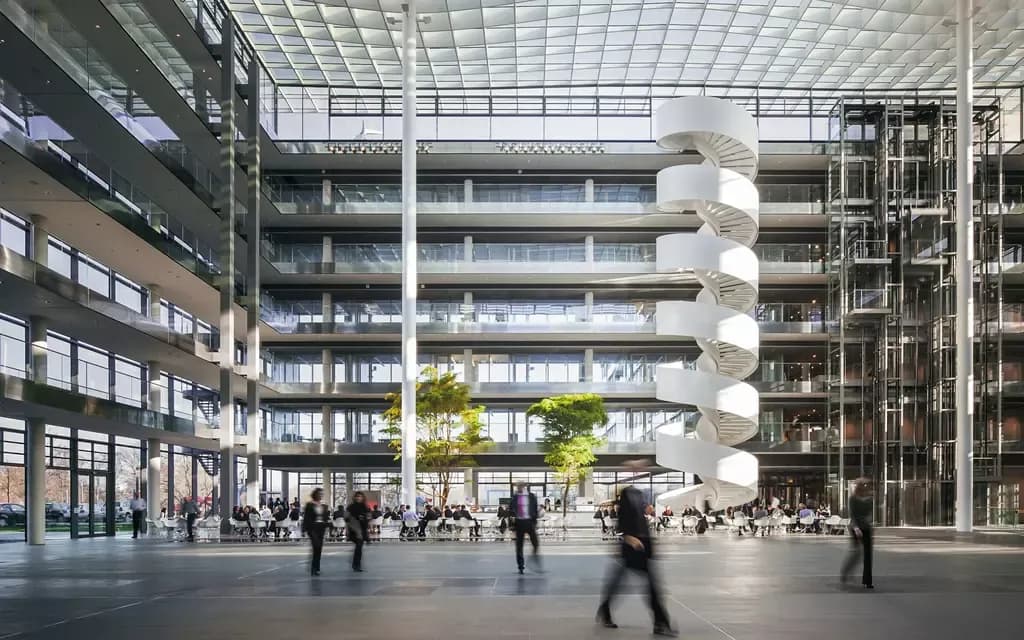 Modern atrium van het HDI Global kantoor met wenteltrap en glazen dak, als beeld bij de HDI Global case